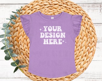 May include: A purple t-shirt with ruffle sleeves and the text "YOUR DESIGN HERE" in white.