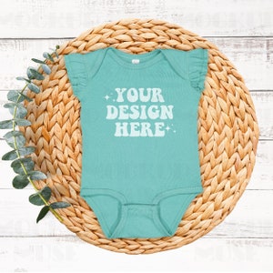 Puede incluir: Un body de bebé turquesa con mangas con volantes y el texto "YOUR DESIGN HERE" en blanco.
