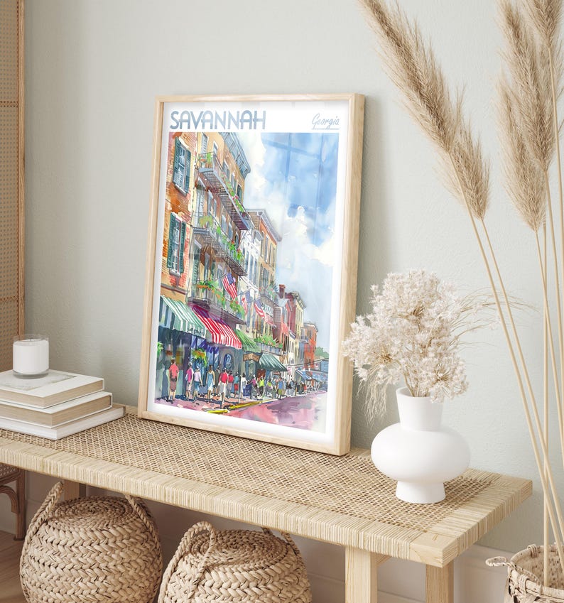 May include: A watercolor painting of a street scene in Savannah, Georgia. The painting depicts a street lined with colorful buildings, shops, and people walking by. The title "SAVANNAH Georgia" is written in the top left corner of the painting.