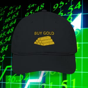 May include: Black baseball cap with the text "BUY GOLD" embroidered in gold above a gold bar graphic. The cap is set against a background of financial data and a rising arrow.