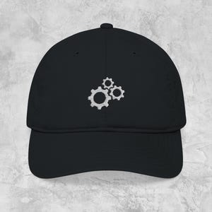 May include: Black baseball cap with a curved brim. The cap features a white embroidered design of three interlocking gears on the front. The hat is made of a soft material and has a classic, casual style.