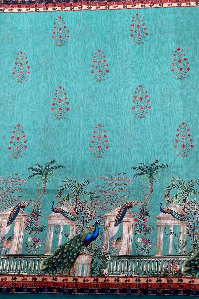 May include: A turquoise fabric featuring a repeating pattern of small red floral sprigs. The lower section displays a detailed scene with peacocks perched on stone pillars, palm trees, and architectural elements, framed by a dark patterned border.