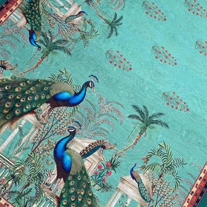 May include: A teal fabric featuring a repeating pattern of peacocks with iridescent blue and green plumage, palm trees, and classical architectural columns. Small red floral motifs are scattered across the background, framed by a decorative border.