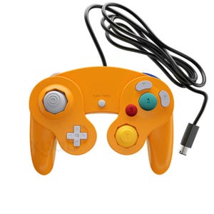 May include: Orange video game controller with a black cable and connector. The controller has a gray joystick, a directional pad, and colored buttons including green, red, and yellow. The text "START / PAUSE" is printed on the controller.