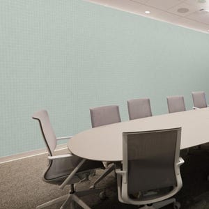 K&ouml;nnte beinhalten: Ein Konferenzraum mit einem gro&szlig;en ovalen Tisch und mehreren grauen St&uuml;hlen. Die St&uuml;hle haben eine Netzr&uuml;ckenlehne und sind auf Rollen. Die Wand ist hellgr&uuml;n mit einem dezenten Rastermuster. Der Raum hat einen neutralen Teppich und Einbauleuchten.