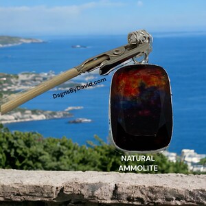 May include: A natural ammolite gemstone pendant with iridescent colors of red, orange, green, and blue. The pendant is set in a silver bezel and hangs from a silver chain.