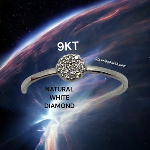 May include: A silver ring with a 9KT natural white diamond set in the center. The ring is set against a background of a starry night sky with a planet in the distance.