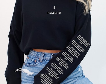 May include: Black cropped sweatshirt with long sleeves and the text "PSALM 121" and a cross on the front. The sleeves have white text printed on them.