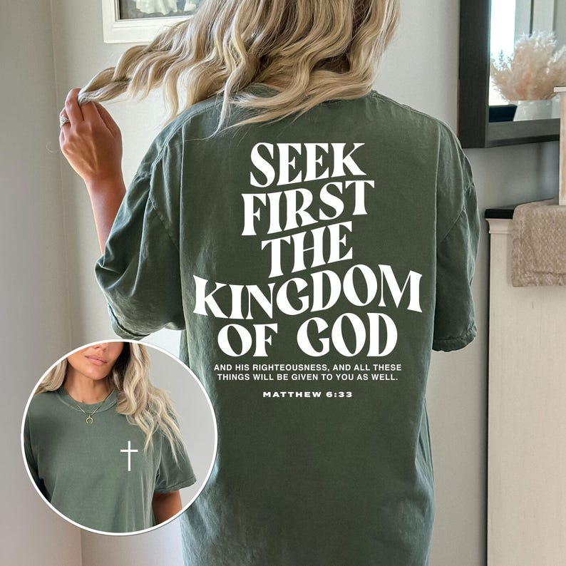 May include: An olive green t-shirt featuring the white text "SEEK FIRST THE KINGDOM OF GOD". The quote "AND HIS RIGHTEOUSNESS, AND ALL THESE THINGS WILL BE GIVEN TO YOU AS WELL. MATTHEW 6:33" is below. A small white cross is on the front of the shirt.