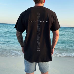 Pu&ograve; includere: T-shirt nera con la scritta "MATTHEW" e un disegno a croce sul retro. La maglietta presenta anche il testo "BUT SEEK FIRST HIS KINGDOM AND HIS RIGHTEOUSNESS, AND ALL THESE THINGS WILL BE GIVEN TO YOU AS WELL. 6:33."
