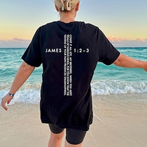 May include: Black t-shirt with white text that reads "JAMES 1:2-3 COUNT IT ALL JOY, MY BROTHERS, WHEN YOU MEET TRIALS OF VARIOUS KINDS, FOR YOU KNOW THAT THE TESTING OF YOUR FAITH PRODUCES STEADFASTNESS."