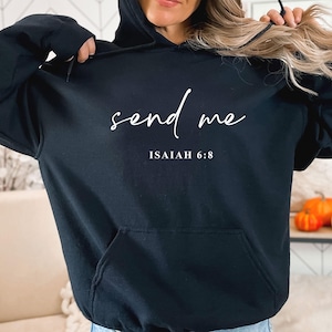May include: Black hoodie with the words "send me" in a cursive font. Below the text is "ISAIAH 6:8" in a smaller font. The sweatshirt has a front pocket and a drawstring hood.