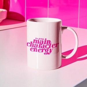 Puede incluir: Taza de cerámica blanca con un diseño rosa que dice "it's giving... main character energy".