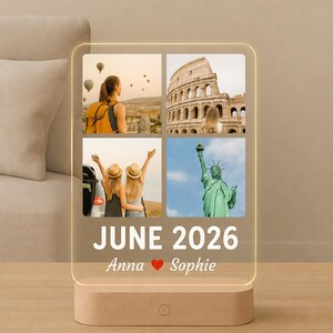 May include: A rectangular acrylic light panel with a wooden base displaying a four-photo collage of travel scenes, including hot air balloons, the Colosseum, two people with hats, and the Statue of Liberty, with the text JUNE 2026 Anna ❤️ Sophie.