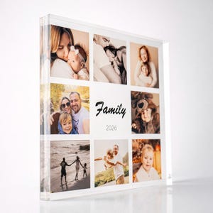 May include: A clear acrylic photo block featuring nine family photos. The word "Family" is written in cursive, with the year "2026" below it. The photos are of various family members, in color and black and white.
