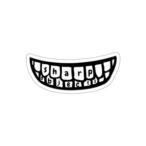 May include: A black and white sticker featuring a wide, curved mouth with teeth. Inside the teeth, the text 'sharp objects' is written in lowercase black letters. The design is outlined in white, creating a bold, graphic illustration of a grin.