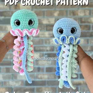 May include: Two crocheted jellyfish toys with large glittery eyes and curly tentacles. The left jellyfish is mint green with pink and white accents. The right jellyfish is light blue with white and mint green accents. Text reads PDF CROCHET PATTERN.
