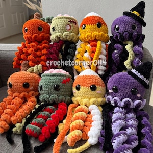 May include: Eight crocheted plush toys arranged in two rows, featuring pumpkin, zombie, candy corn, and witch octopus designs in orange, green, yellow, white, and purple yarn with black safety eyes and the text crochetcorner0114 visible.