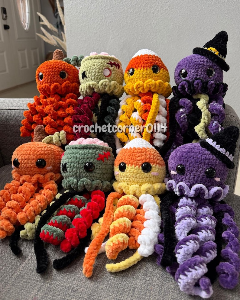 May include: Eight crocheted plush toys arranged in two rows, featuring pumpkin, zombie, candy corn, and witch octopus designs in orange, green, yellow, white, and purple yarn with black safety eyes and the text crochetcorner0114 visible.