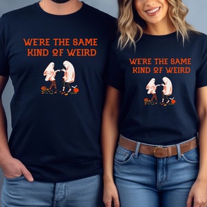 May include: Two navy blue t-shirts with a graphic of two ghosts holding hands and the text "We're the same kind of weird".