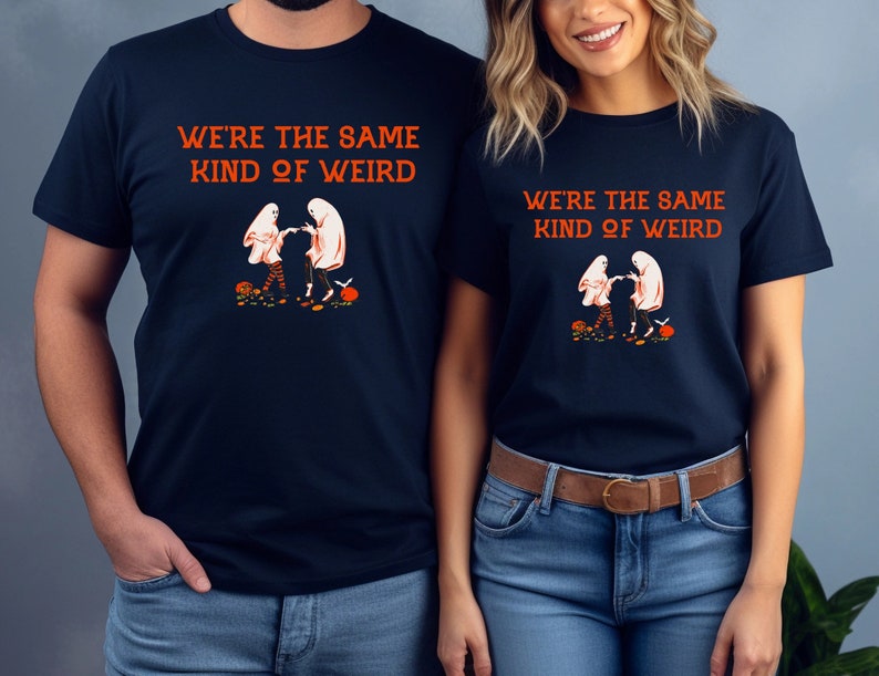 May include: Two navy blue t-shirts with a graphic of two ghosts holding hands and the text "We're the same kind of weird".