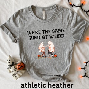 May include: Gray t-shirt with the text "We're the same kind of weird" and a graphic of two ghosts holding hands. The t-shirt is labeled "athletic heather".