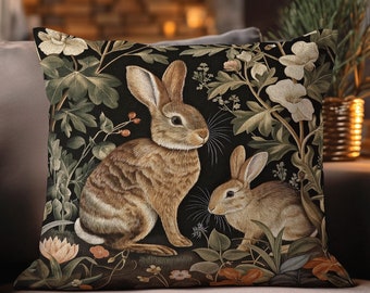 May include: A decorative pillow featuring a woven tapestry design of two rabbits in a forest setting. The rabbits are brown and white, and the forest is depicted in shades of green and black. The pillow has the text "INK & SHADOW Original Fine Art Woven Pillow" printed on the bottom.