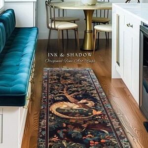 May include: A long, rectangular rug with a detailed, colorful design featuring a dragon, trees, and flowers. The rug is placed in a kitchen with a teal bench, artwork, and a round table. The text "INK & SHADOW Original Fine Art Rugs" is visible.