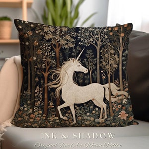 May include: A square throw pillow featuring a woven tapestry design of a white unicorn standing in a dark forest. The scene includes detailed trees, foliage, and flowers in muted earth tones. The text INK & SHADOW Original Fine Art Woven Pillow is printed below the pillow.