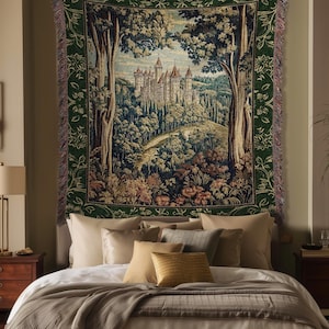 May include: A rectangular woven wall tapestry featuring a detailed landscape scene of a castle nestled within a dense forest. The tapestry has a dark green floral border and frayed edges, depicting trees, rolling hills, and a stone castle structure.