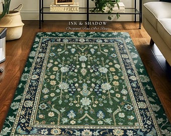 May include: A rectangular area rug featuring a deep green background with a detailed floral pattern in shades of light blue, cream, and dark navy. The rug has a wide decorative border with intricate botanical motifs and a central medallion design.