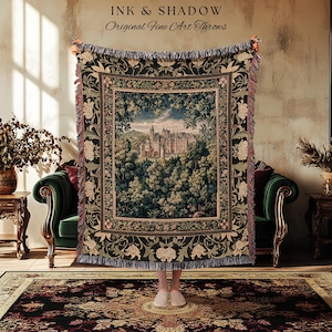 May include: A tapestry throw blanket with a castle scene framed by a floral border. The throw is dark green with cream and red accents, and the text "INK & SHADOW Original Fine Art Throws" is at the top.