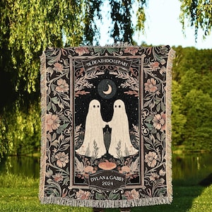 Op de afbeelding: Een zwarte sprei met een bloemenrand en een centraal ontwerp met twee witte spookfiguren die elkaars hand vasthouden onder een halve maan. De tekst "TIL DEATH DO US PART" en "DYLAN & GABBY 2024" zijn ook zichtbaar.