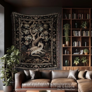May include: A rectangular woven wall tapestry featuring a central illustration of a light-colored dragon resting beneath a large tree. The design includes intricate floral borders in muted tones against a dark black background with fringed edges.