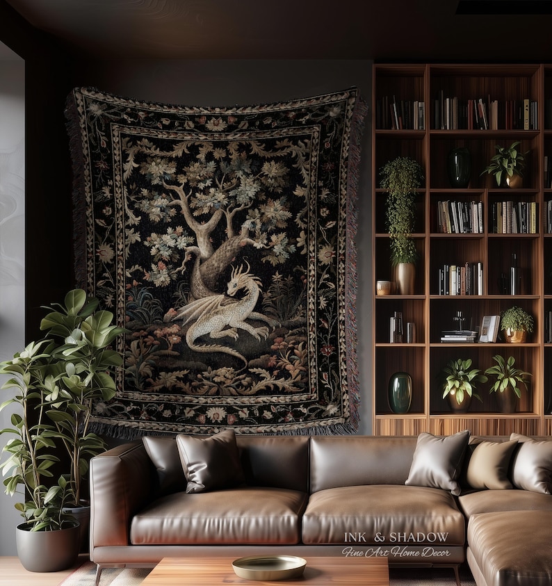 May include: A rectangular woven wall tapestry featuring a central illustration of a light-colored dragon resting beneath a large tree. The design includes intricate floral borders in muted tones against a dark black background with fringed edges.