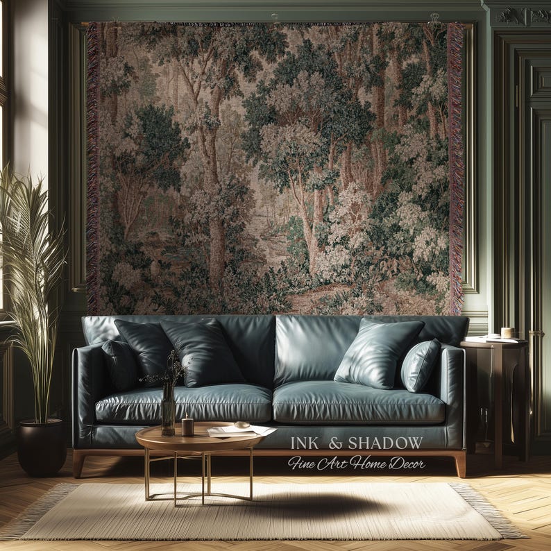 May include: A living room scene featuring a teal leather sofa, a round wooden coffee table, and a woven rug. A large tapestry depicting a forest scene hangs on the wall. The text "INK & SHADOW Fine Art Home Decor" is visible.