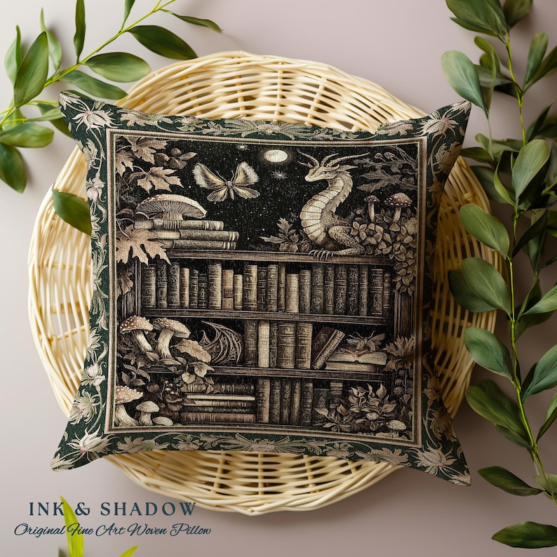 May include: A green throw pillow with a woven tapestry design featuring a bookshelf filled with books, a dragon, mushrooms, and a butterfly. The text "INK & SHADOW Original Fine Art Woven Pillow" is printed at the bottom of the pillow.