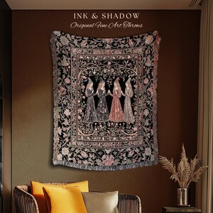 May include: A woven throw blanket featuring a central rectangular panel with four figures in pointed hats standing in a circle, surrounded by a floral border. The text INK & SHADOW Original Fine Art Throws is printed above the black and multi-colored textile.