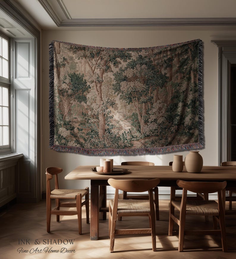 May include: A tapestry depicting a forest scene with trees and foliage in shades of green, brown, and beige. The tapestry is fringed and hangs above a wooden dining table with chairs. The text "INK & SHADOW Fine Art Home Decor" is at the bottom.