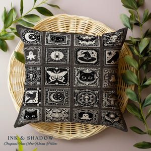 May include: Black and white pillow with a patchwork design featuring various Halloween-themed illustrations, including bats, ghosts, cats, spiders, moons, and pumpkins. The pillow is on a woven wicker surface.