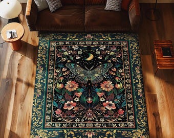 May include: A rectangular area rug with a dark background, featuring a large moth design with a crescent moon and floral elements. The rug has a teal border and is surrounded by a brown sofa and wooden furniture.