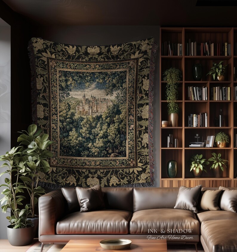 May include: A woven wall tapestry featuring a detailed landscape scene of a castle nestled within a dense forest, surrounded by a decorative floral border in shades of dark green, gold, and black, with fringed edges hanging on a wall.