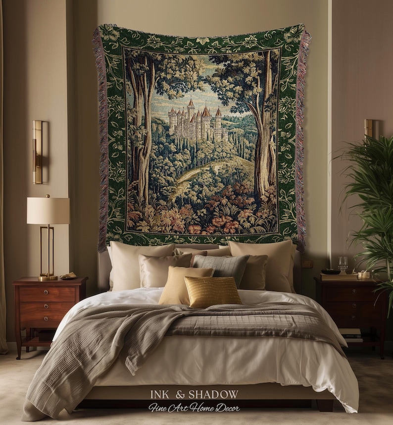 May include: A rectangular woven wall tapestry featuring a detailed landscape scene of a castle nestled within a dense forest. The tapestry has a dark green floral border and frayed edges, depicting trees, rolling hills, and a stone castle structure.