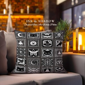 May include: Black and white woven pillow with a Halloween theme. The pillow features a variety of spooky and whimsical designs, including bats, ghosts, spiders, skulls, and a witch's hat. The text "INK & SHADOW Original Fine Art Woven Pillow" is printed on the pillow.