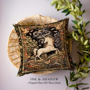 K&ouml;nnte beinhalten: Ein schwarzes Samtkissen mit einem Gobelinmuster, das ein wei&szlig;es Einhorn in einer Waldlandschaft zeigt. Das Kissen hat einen goldenen Rand und der Text "INK & SHADOW Original Fine Art Faux Suede" ist unten aufgedruckt.