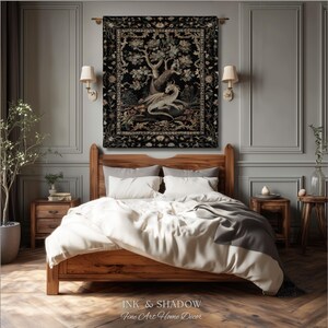 May include: A rectangular wall tapestry featuring a central illustration of a white dragon resting beneath a large tree, surrounded by a detailed floral border in shades of black, gold, and cream, hanging above a wooden bed frame.
