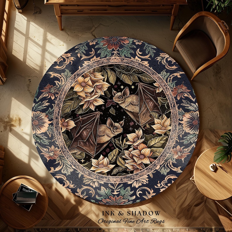 May include: Round area rug with a dark blue border featuring floral and scrollwork patterns. The center design showcases bats, flowers, and foliage. The rug has the text "INK & SHADOW Original Fine Art Rugs" at the bottom.