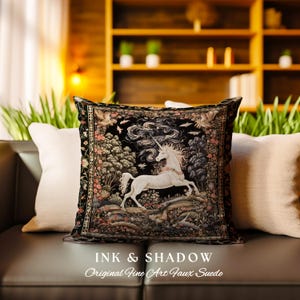 K&ouml;nnte beinhalten: Ein schwarzes Kissen mit einem Gobelinmuster, das ein wei&szlig;es Einhorn zeigt, das durch einen Wald rennt. Das Kissen tr&auml;gt den Text "Ink & Shadow Original Fine Art Faux Suede", der unten aufgedruckt ist.