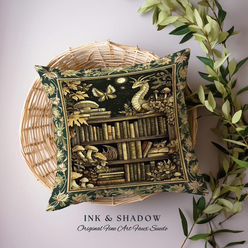 May include: A green throw pillow with a gold and black illustration of a bookshelf with books, mushrooms, and a dragon. The text "Ink & Shadow Original Fine Art Faux Suede" is at the bottom of the pillow.