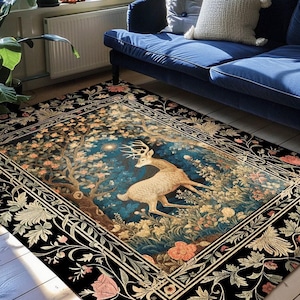 May include: A rectangular area rug featuring a central scene of a white deer standing in a forest with a dark blue background, surrounded by a black border with floral patterns. The text INK & SHADOW Original Fine Art Rugs is printed at the bottom.
